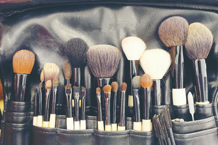 Professional makeup brushes cosmetic in tube, leather bag. close-up brush, makeup tools of , powder, set of different objects for makeup artist in their holder. Set of make up products arrangedの写真素材