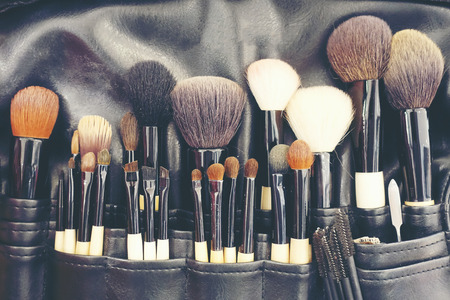 Professional makeup brushes cosmetic in tube, leather bag. close-up brush, makeup tools of , powder, set of different objects for makeup artist in their holder. Set of make up products arrangedの写真素材