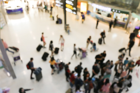 blurred image of crowd of travelling people or passenger walking with a luggage from flight in the international airport terminal with beautiful bokeh from the light,advertise & traveling concept.の写真素材