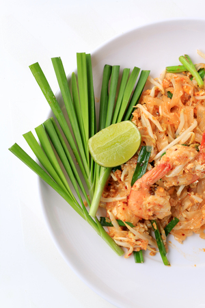 Pad Thai, stir-fried rice noodles with shrimp in white plate with slide lemon and green vegetable. The one of Thailand's national main dish. the popular food in Thailand. Thai Fried Noodlesの写真素材