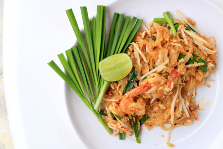 Pad Thai, stir-fried rice noodles with shrimp in white plate with slide lemon and green vegetable. The one of Thailand's national main dish. the popular food in Thailand. Thai Fried Noodlesの写真素材