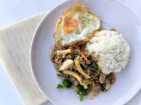 stir fried minced pork with basil eating with rice and fried egg on white background. Thai Food.の写真素材