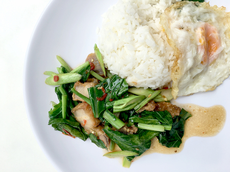 Stir fry Kai Land and crispy pork, stir fried rice with rice in white dish on white background. Thai style food.の写真素材
