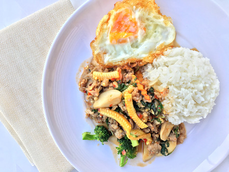 stir fried minced pork with basil eating with rice and fried egg on white background. Thai Food.の写真素材