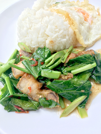 Stir fry Kai Land and crispy pork, stir fried rice with rice in white dish on white background. Thai style food.の写真素材