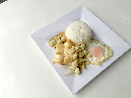 Stir Fried Tofu in Chinese Style,Deep Fried Tofu with Gravy Sauce ,Stir fried tofu with cauliflower and thai style fried egg in white plate on white background. Vegetarian Food, healthy food.の写真素材