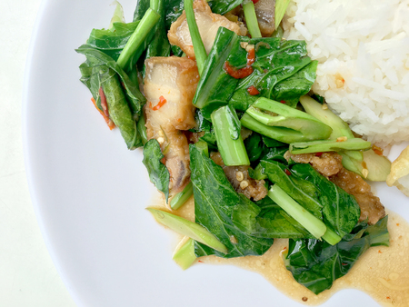 Stir fry Kai Land and crispy pork, stir fried rice with rice in white dish on white background. Thai style food.の写真素材