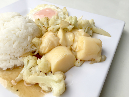 Stir Fried Tofu in Chinese Style,Deep Fried Tofu with Gravy Sauce ,Stir fried tofu with cauliflower and thai style fried egg in white plate on white background. Vegetarian Food, healthy food.の写真素材