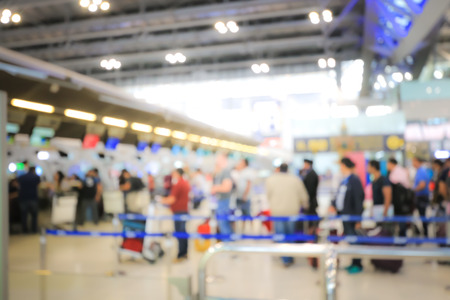 Blurred image of airport check-in counters with passengers and crowd of people control barriers with bokeh in international airport, que, travel, tourism, business concept Abstract Blur Background.の写真素材