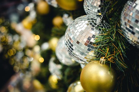 Golden & Silver color of christmas ball on the branches fir with beautiful light bokeh, Decorated Christmas tree. New Year Decoration festive background with vintage tone and selective focus. copy space.の写真素材