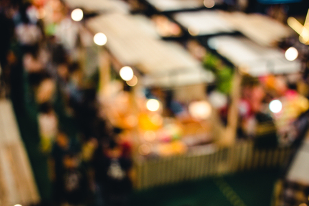 abstract blur image of people go to shopping in night market festival for background usage, vintage tone, top view or bird eye view composition.の写真素材