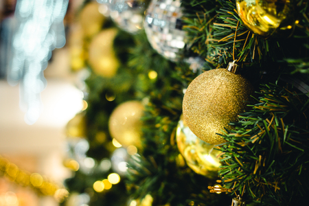 Golden & Silver color of christmas ball on the branches fir with beautiful light bokeh, Decorated Christmas tree. New Year Decoration festive background with vintage tone and selective focus. copy space.の写真素材