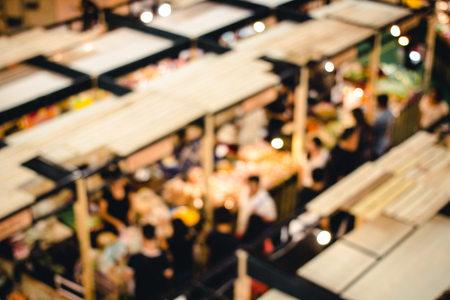 abstract blur image of people go to shopping in night market festival for background usage, vintage tone, top view or bird eye view composition.の写真素材