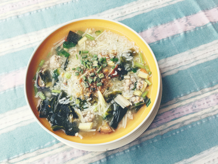 rice soup with vegetables, chickenin and pork in white bowl. Thai style food.の写真素材