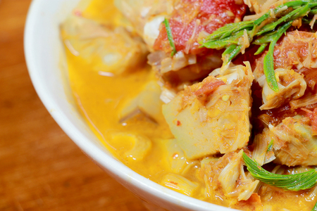 Northern Thailand local food called Kaeng Khanun-on is cooking like a young jack fruit soup with pork spare rib Thai herb, Climbing Wattle, Acacia pennata, red eggplant in white bowl on wooden table.の写真素材