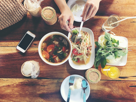 Top view Thai food on table: Eating north eastern foods (SOM TUM - Spicy Papaya Salad, Sticky rice, NUM TOK - Spicy Soup). Local and traditional way. Thai Food Background. enjoy eating conceptの写真素材