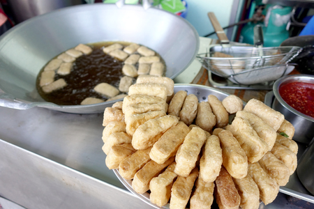 Crispy deep fried tofu after placed on the drying rack for the excess oil to drip off from street vendor at Thai street food vendor market, Vegetarian food, Thai food, snacks Thai style.の写真素材