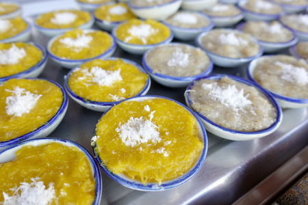 Thai sweets of coconut milk Custard (called "Khanom Thuai") in small porcelain cup at street food market. Traditional Thai dessert. group of Homemade kind of Thai sweetmeat. top viewの写真素材