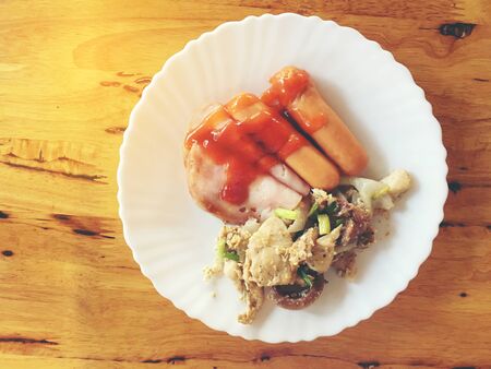 Homemade bavarian Sausages and Han in white paper dish for Breakfast in the morning on wooden table.の写真素材
