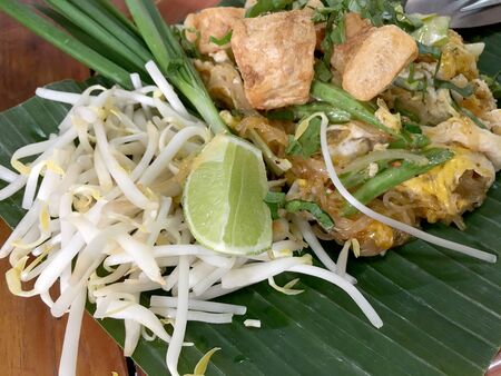Pad Thai. Thai style fried noodles with shrimps prawns and vegetables on banana leaf on wooden table. Traditional Thai food menu for restaurant. Asian food.Top view & flat layの写真素材