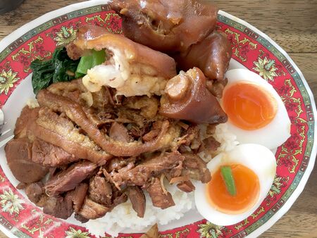 Rice with pork legs with boiled egg and sweet gravy sauce style chinese food in dish on the table, Thai food.Famous food in Thailandの写真素材