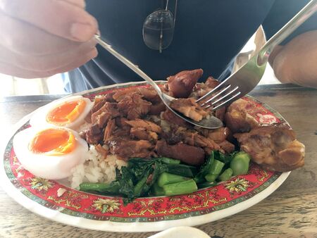 Rice with pork legs with boiled egg and sweet gravy sauce style chinese food in dish on the table, Thai food.Famous food in Thailandの写真素材