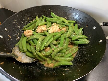 Vegetables Stir-Fry Recipe of pea with prawns or shrimps in black iron pan at the kitchen. Cooking concept.の写真素材