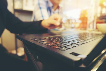 Close up of business man's hands sitting and present his business report from notebook, laptop  during coffee break in restaurants. business person at workplace concept.の写真素材