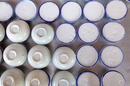Thai sweets of coconut milk Custard (called "Khanom Thuai") in small porcelain cup at street food market. Traditional Thai dessert. group of Homemade kind of Thai sweetmeat. top viewの写真素材