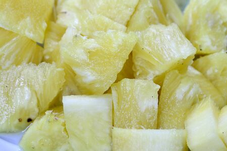 Close up slice pineapple background texture in white dish. Slide and piece of fresh fruit.の写真素材