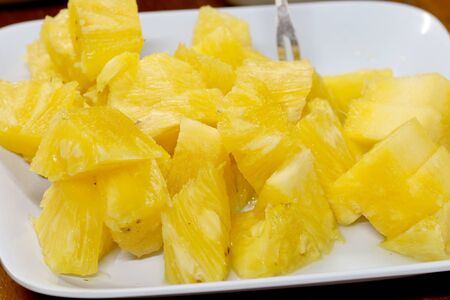 Close up slice pineapple background texture in white dish. Slide and piece of fresh fruit.の写真素材