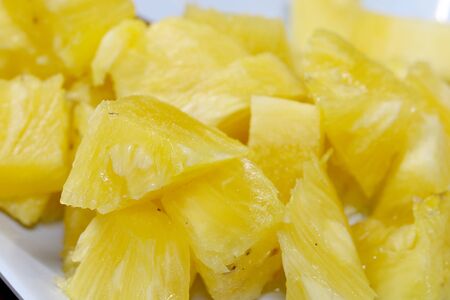Close up slice pineapple background texture in white dish. Slide and piece of fresh fruit.の写真素材