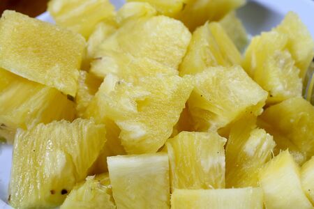 Close up slice pineapple background texture in white dish. Slide and piece of fresh fruit.の写真素材