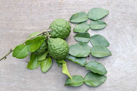 Group of fresh Bergamot fruit and bergamot leaves on wooden table backgroundの写真素材