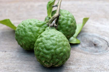 Group of fresh Bergamot fruit and bergamot leaves on wooden table backgroundの写真素材