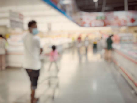 Blurred image of people shopping in supermarket. Cashier with long line of people waiting at checkout counter in fitness store at outlet shopping mall in Thailand.の写真素材