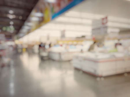 Blurred image of people shopping in supermarket. Cashier with long line of people waiting at checkout counter in fitness store at outlet shopping mall in Thailand.の写真素材