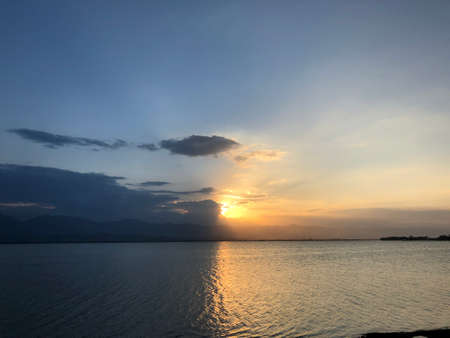 Beautiful sunset and evening sky with mountain and clouds at the beach for background. nice view in the north of Thailand.の写真素材
