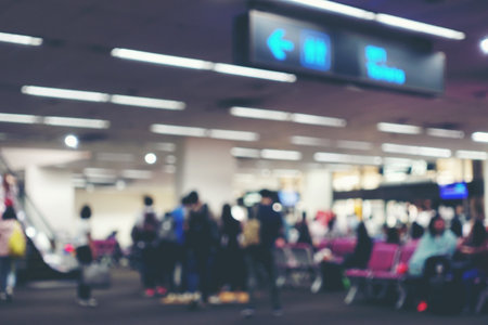 Abstract Blur Background of people or passenger walking in or hurry up in airport transport terminal, Airport Check-In Counters With Many Passengers With Bokeh. vintage tone with light effect.の写真素材