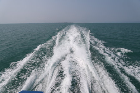 Ship wake on the ocean.aves from the back of a speed boat over the water's surface in sea. Waves behind a boat on a clear blue seaの写真素材