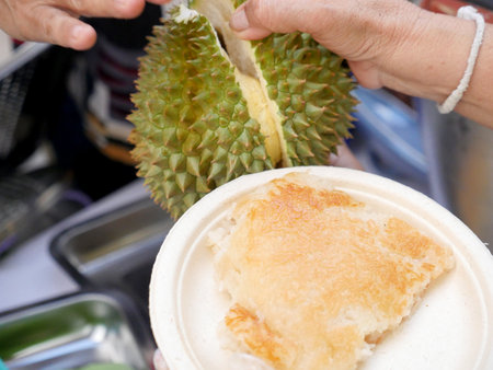 Asian Thai dessert tropical sweet durian peel with yellow bean, Ripe durian rice cooked with coconut milk grill at the market in Southern Thailand, Durian sticky rice summer tropical fruit food.の写真素材