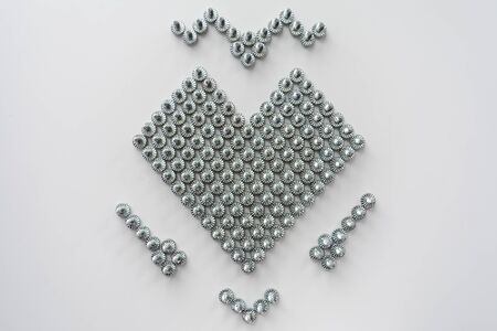 heart symbol made of steel screws, abstract background