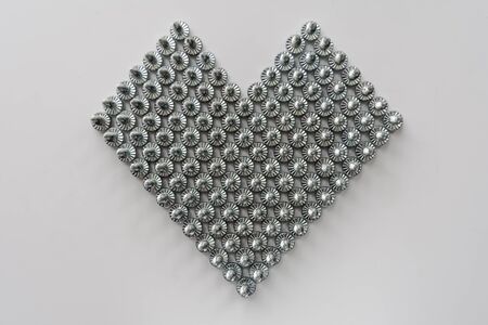 heart symbol made of steel screws, abstract backgroundの写真素材