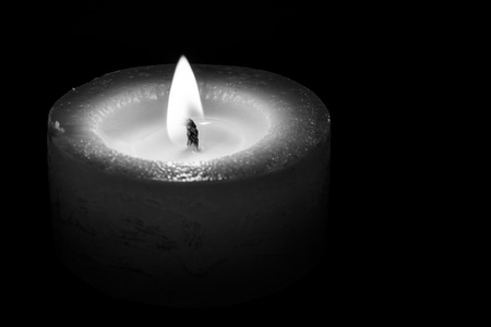 low candle burns at dusk, a candle fire on a black backgroundの写真素材