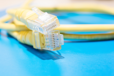plastic connector RJ-45 and yellow cable UTP type twisted pair for connection to a computer network,...