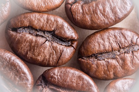Fried brown natural coffee beans, macro abstraction background