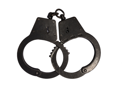 Black metal handcuffs with small scratches on white isolated backgroundの写真素材