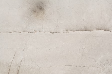 Texture of the surface of an old antique wall with a plaster layer destroyed from moisture, a lot of cracks, irregularities, blisters on the wall, abstract backgroundの写真素材