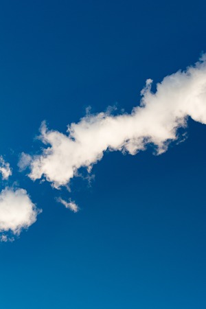 thick white smoke on a background of blue sky, abstract backgroundの写真素材