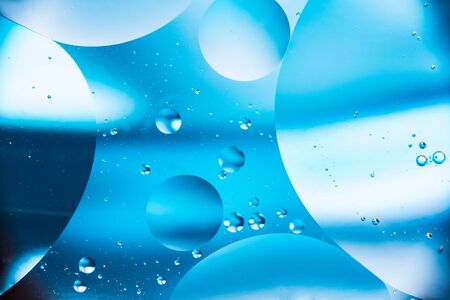 mixing water and oil, beautiful color abstract background based on blue and white circles and ovals, macro abstractionの写真素材